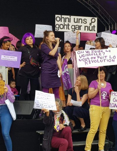 Anna Tanner hält eine Rede am Frauenstreik umgegeben von Aktivist:innen